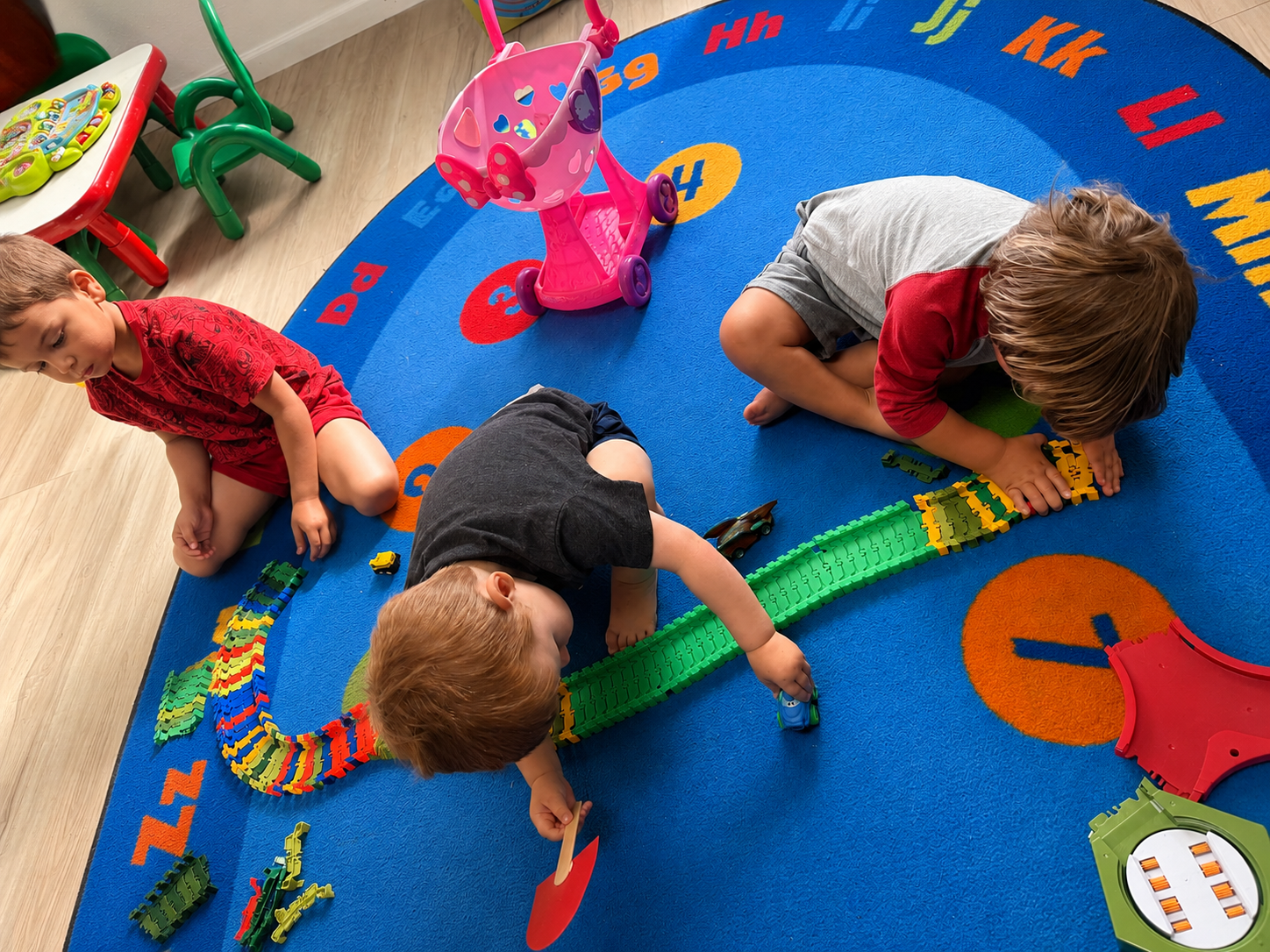 Children playing together with a colorful toy track